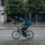 man in blue shirt riding bicycle on road during daytime